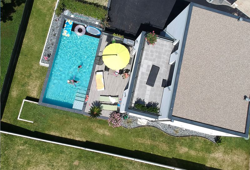 Vue aérienne d'une maison avec piscine, terrasse et pelouse