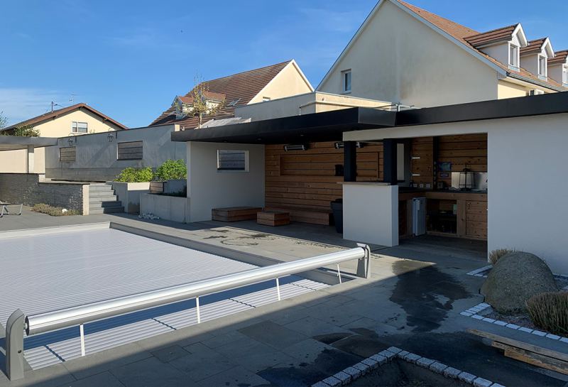 Piscine avec volet roulant et cuisine d'extérieur sous abri