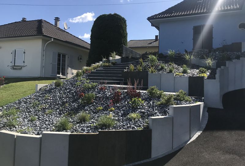 Massifs de graminées dans des jardinières en béton le long d'un escalier